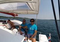 skipper and girl behind steering wheel of trimaran neel 45 yacht